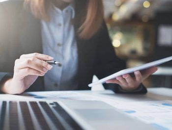 Businesswoman hold pen and works on the digital tablet analyse online infomation.